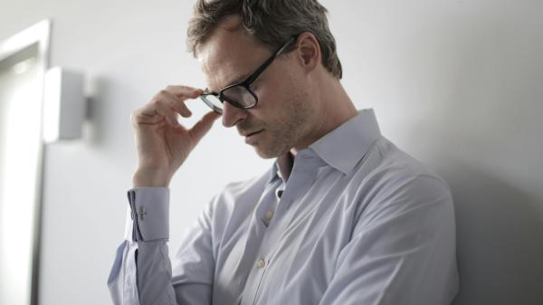 A man presses fingers to his head in frustration