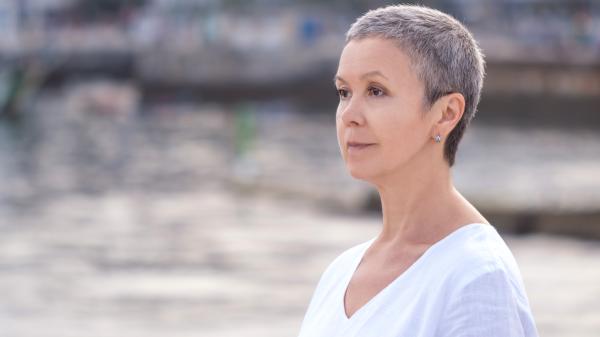 A woman with short hair stares out into the distance