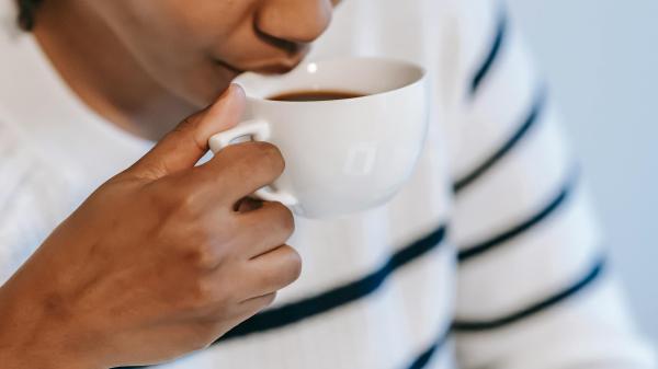 Woman drinks from white mug