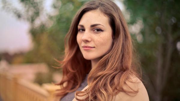 Woman with brown hair looks into the camera