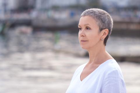 Woman in white t-shirt pensively looks forward